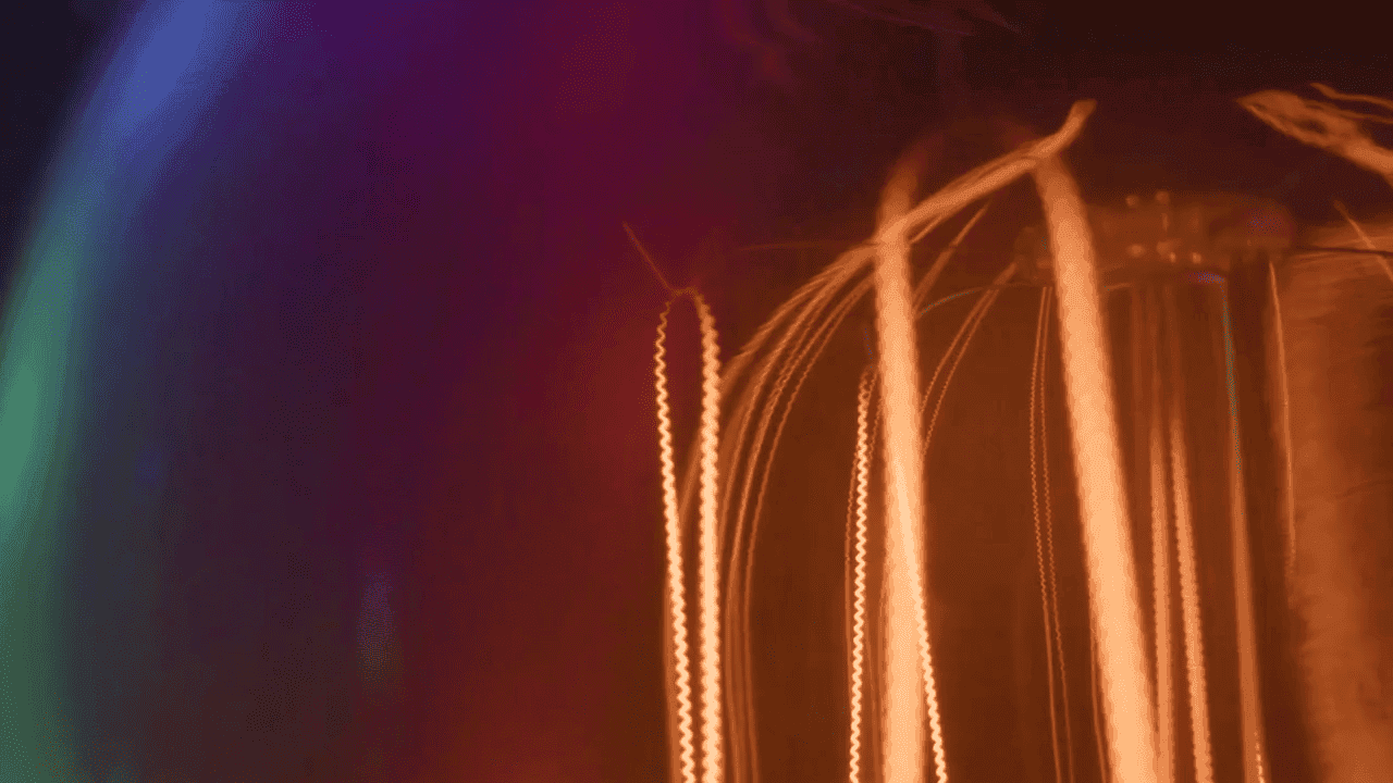 Abstract orange light trails rising against dark purple background